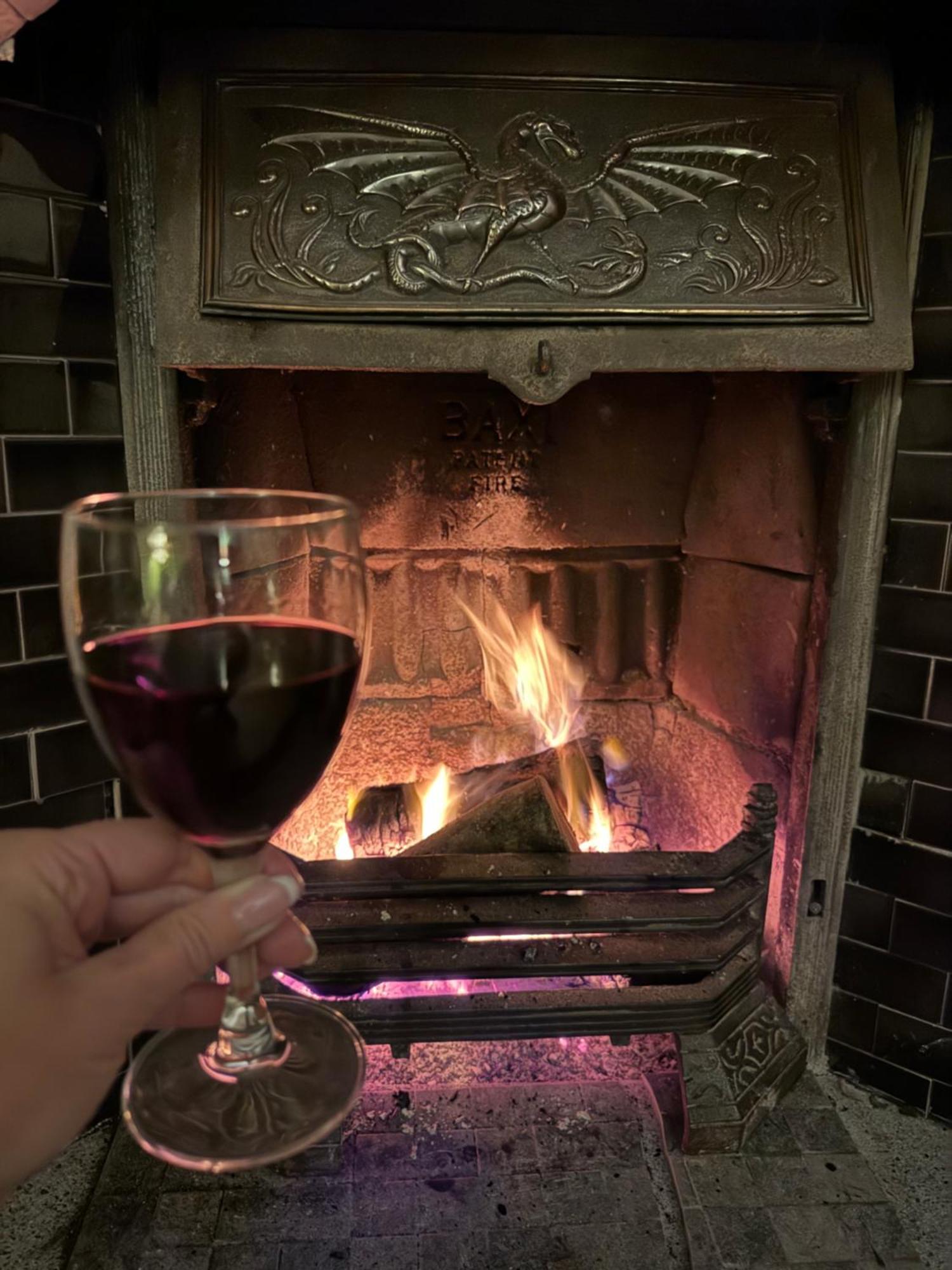 Clone Country House 어흐림 외부 사진 A glass of red wine in front of a fireplace